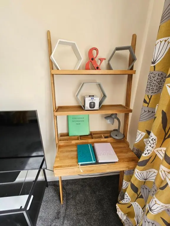 a desk in a room with a bed at Modern Dornoch Apartment in Dornoch