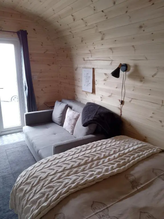 a bedroom with a bed and a couch in a room at Faodail 'a lucky find' in Dunbeath