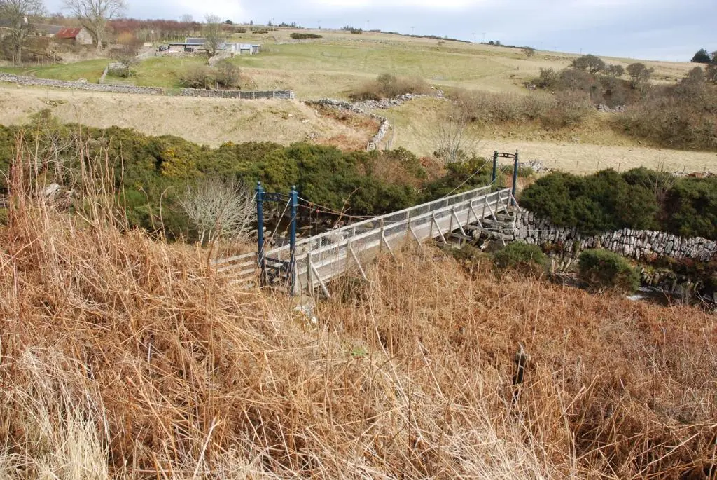 a wooden bridge on a hill with grass and trees at Faodail 'a lucky find' in Dunbeath