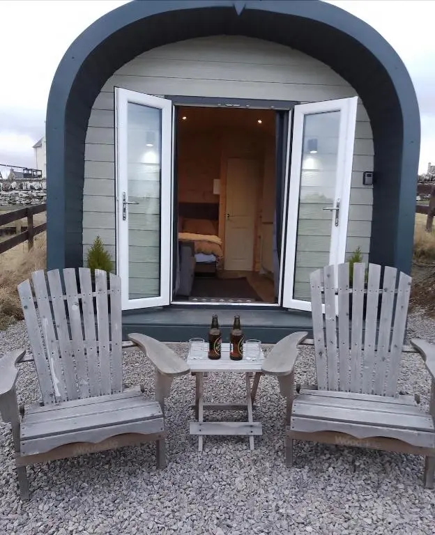 two chairs and a table in front of a house at Faodail 'a lucky find' in Dunbeath
