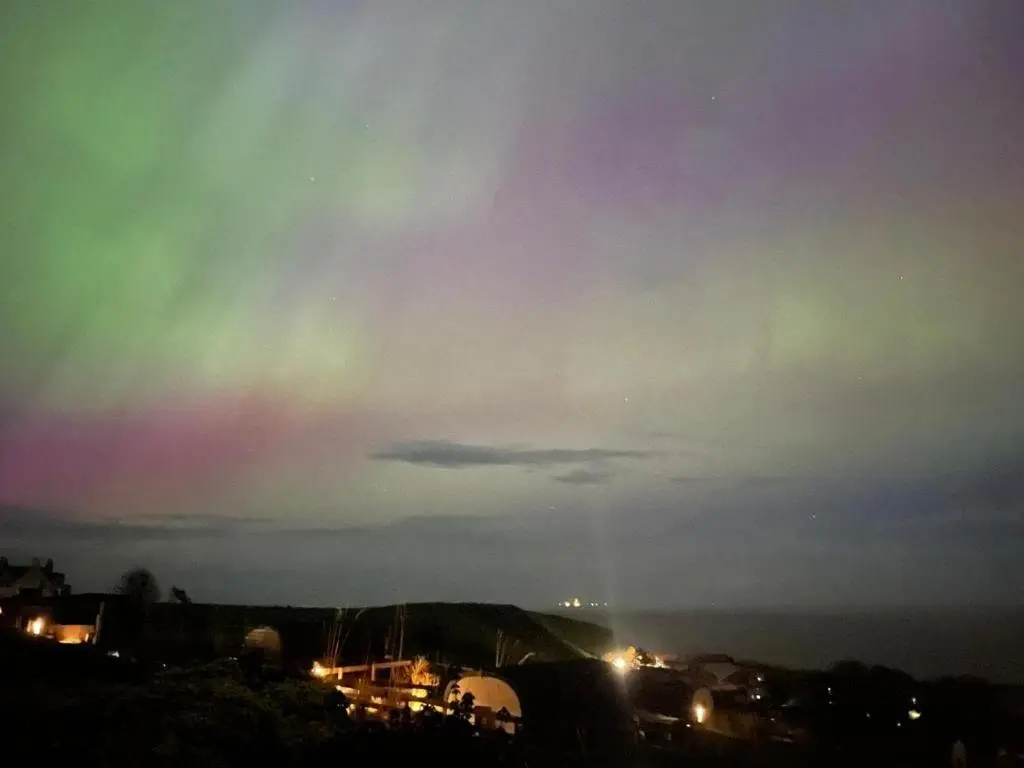 a rainbow in the sky over a city at night at Bruadarach 'Visionary, Dreamer' in Dunbeath