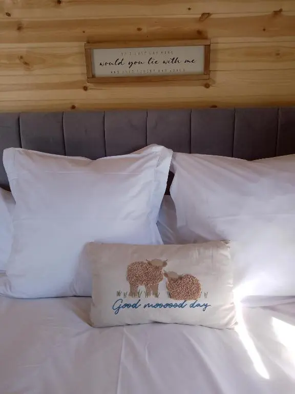 a bed with white pillows with a sign on it at Bruadarach 'Visionary, Dreamer' in Dunbeath