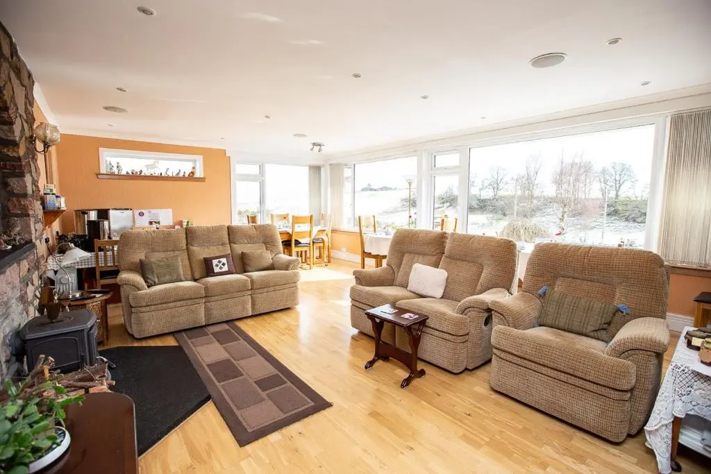 a living room with two couches and a table at Ornum House in Beauly