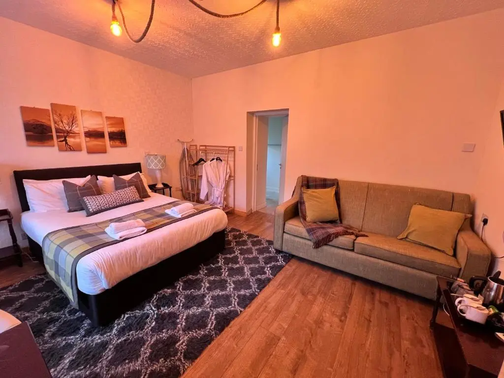 a bedroom with a bed and a couch at Achilty Guest House in Contin