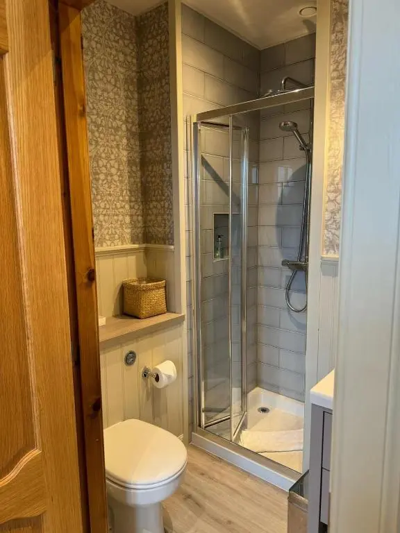 a bathroom with a toilet and a glass shower at Townhouse on the Square, Dornoch in Dornoch