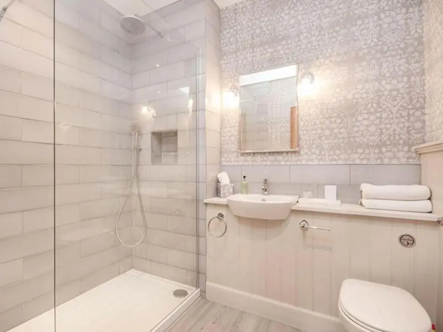 a bathroom with a shower and a toilet and a sink at Townhouse on the Square, Dornoch in Dornoch
