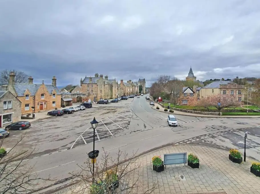 an empty street in a town with houses and cars at Townhouse on the Square, Dornoch in Dornoch