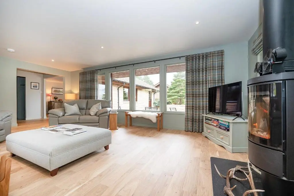 a living room with a couch and a tv at Greenwood - Stunning Scandinavian Style Home in the heart of Ballater Royal Deeside in Ballater