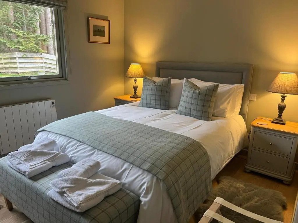 a bedroom with a large bed with towels on it at Greenwood - Stunning Scandinavian Style Home in the heart of Ballater Royal Deeside in Ballater