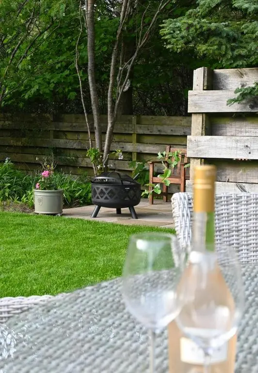 a bottle of wine sitting on a table with a wine glass at Greenwood - Stunning Scandinavian Style Home in the heart of Ballater Royal Deeside in Ballater