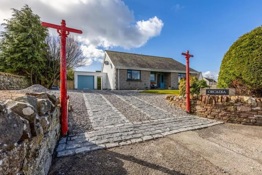 a red cross in front of a house at Orcadia Sutherland Road Dornoch IV25 3SX in Dornoch