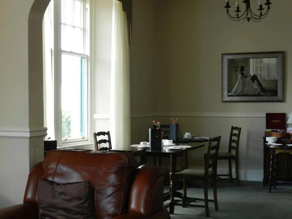 a dining room with a table and a leather chair at Highlander Inn in Craigellachie