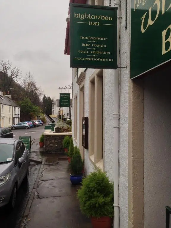 a green sign on the side of a building at Highlander Inn in Craigellachie