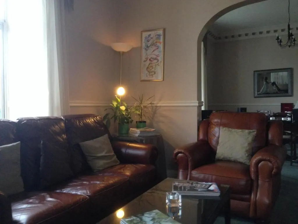 a living room with two leather couches and a table at Highlander Inn in Craigellachie