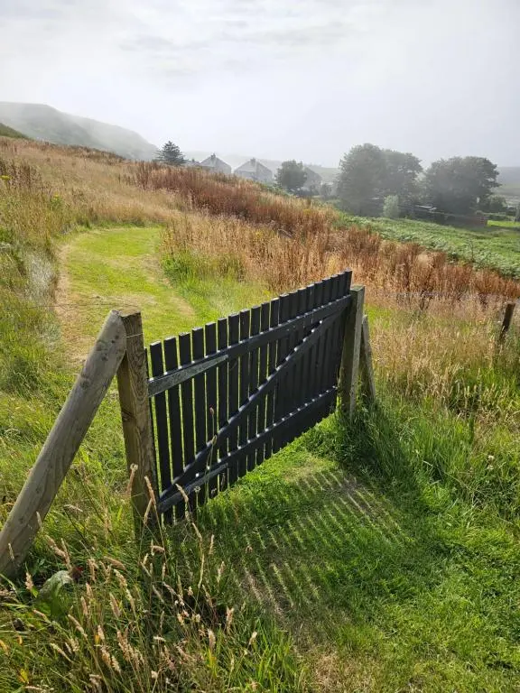 a bench sitting in the grass in a field at Camhanaich 'Half light of dawn' in Dunbeath