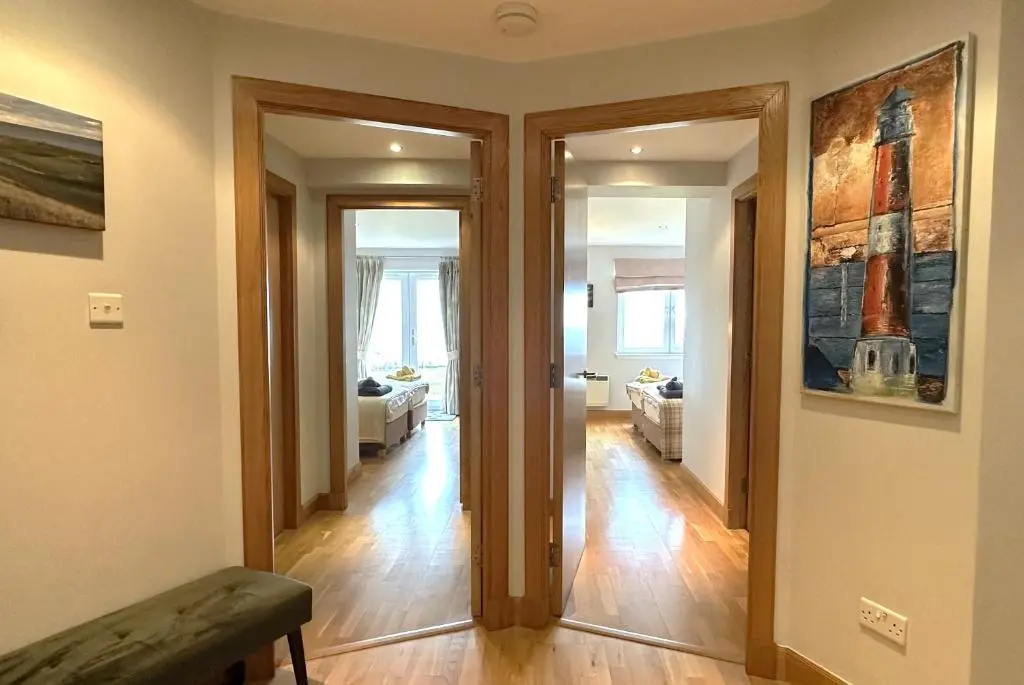 a room with a hallway with two doors and a living room at No2 The Links Apartment, Brora in Brora