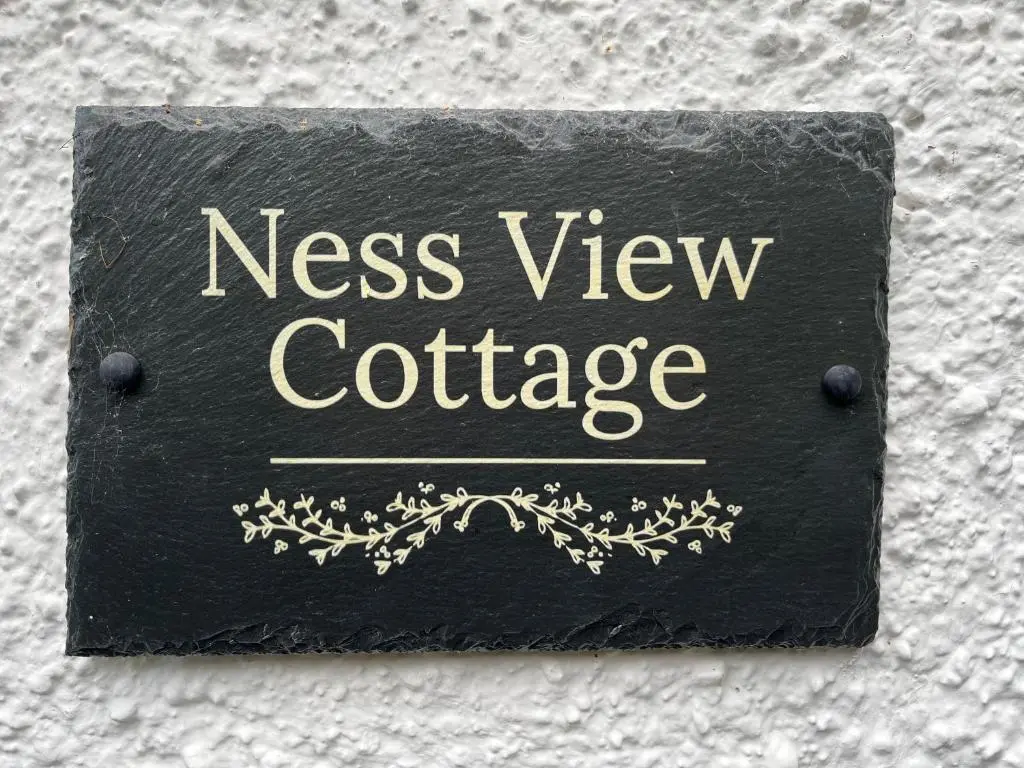 a sign that reads mess view coffee on a wall at Ness View Cottage in Fort Augustus