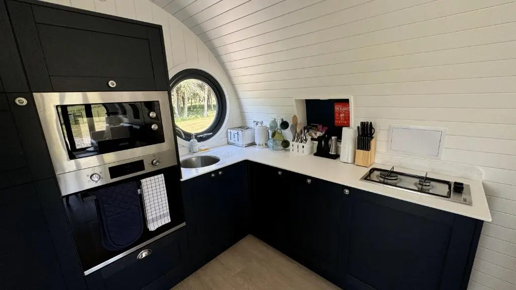 a small kitchen with a sink and a microwave at Juniper Lodges in Inverness