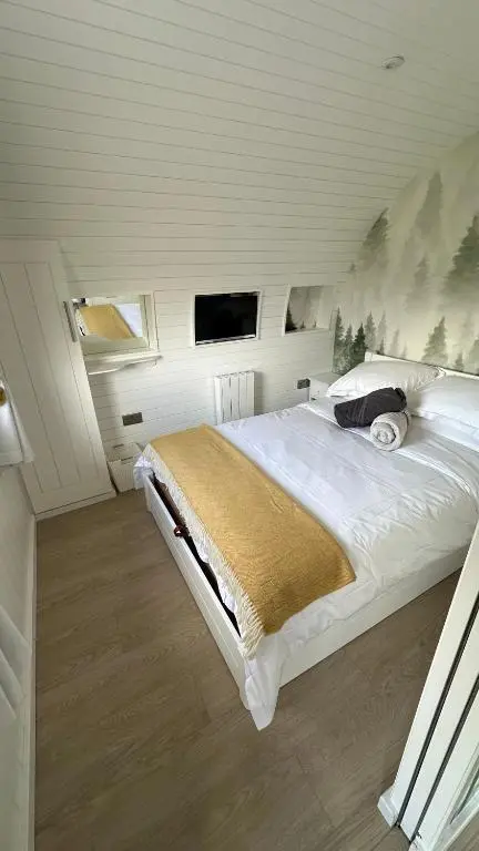 a bedroom with a large bed in a attic at Juniper Lodges in Inverness
