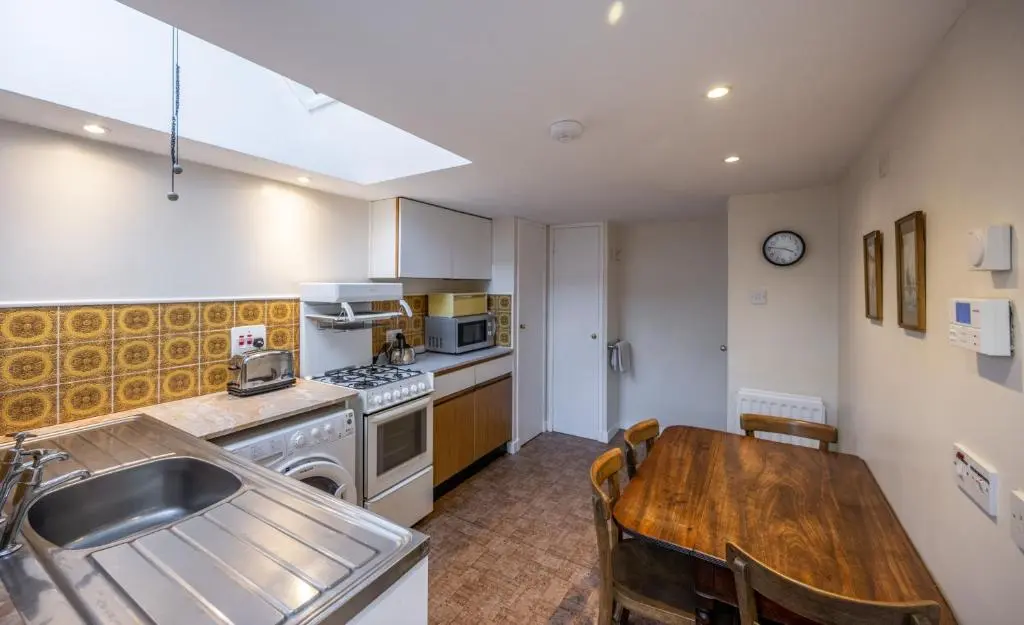 a kitchen with a wooden table and a dining room at 7 Shorehead, Portsoy in Portsoy