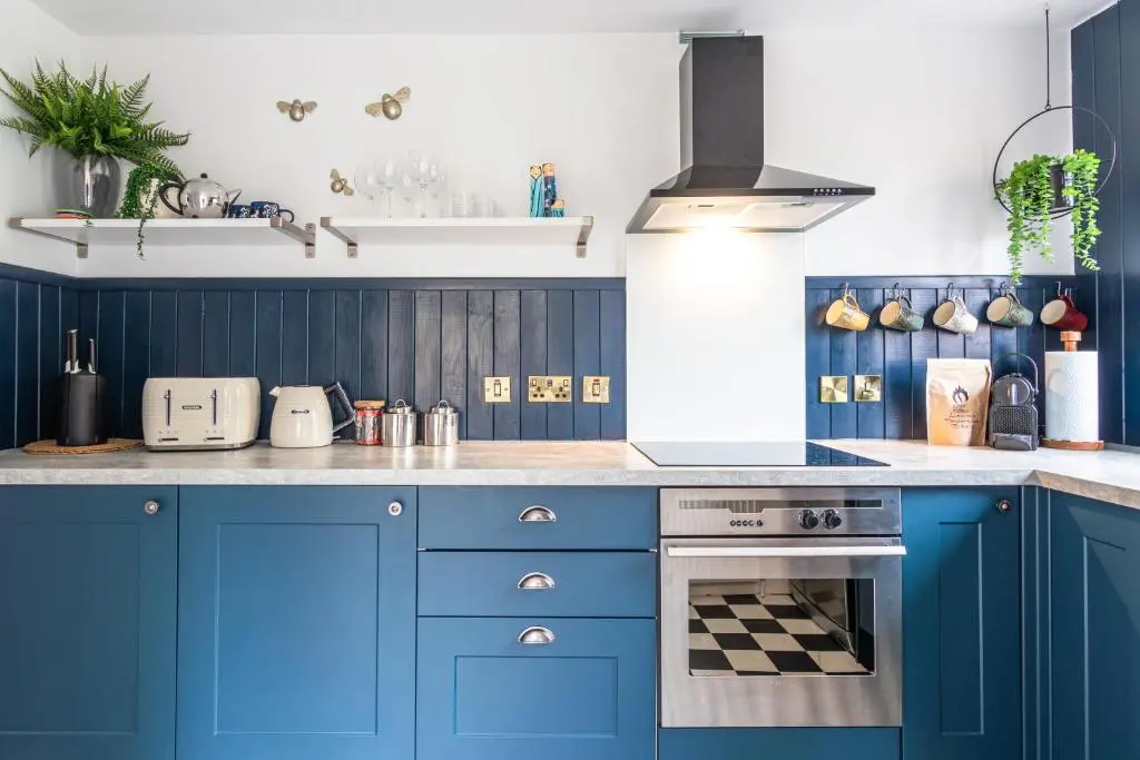 a kitchen with blue cabinets and a stove at Lachie's Townhouse in Inverness