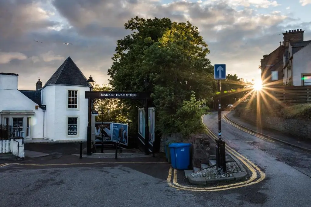 a bus stop next to a white building at Haugh Hideaway in Inverness