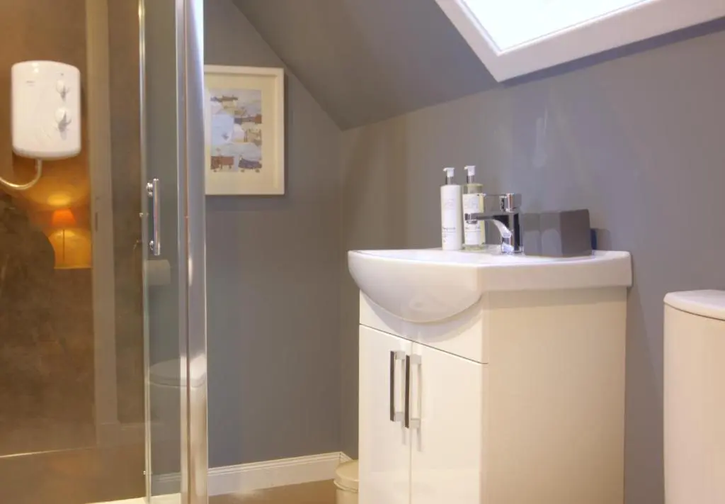 a bathroom with a sink and a shower at Otago Cottage, Brora in Brora