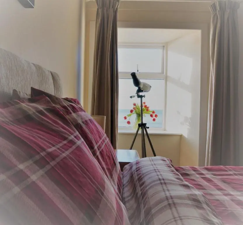 a bedroom with a bed with a camera on a tripod at The Pennan Inn in Pennan