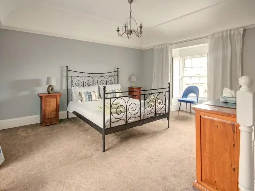 a bedroom with a bed and a desk and a window at Anvil House, Golspie in Golspie