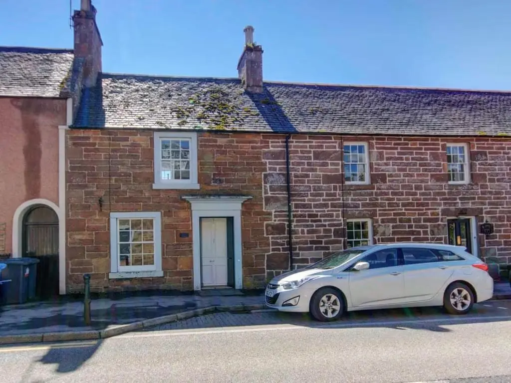 a white car parked in front of a brick building at Anvil House, Golspie in Golspie