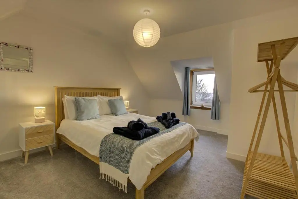 a bedroom with a bed with a teddy bear on it at Tigh-na-Mara, Helmsdale in Helmsdale