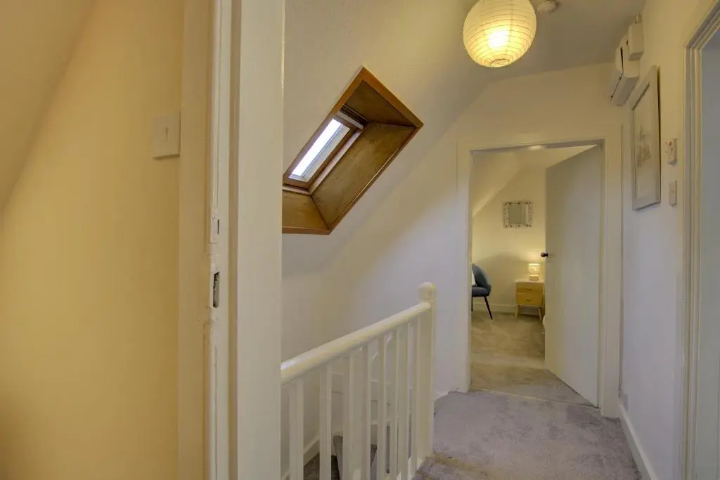 a hallway with a stairway with a window and a ceiling at Tigh-na-Mara, Helmsdale in Helmsdale