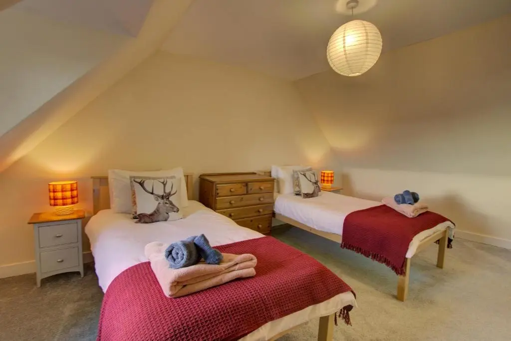 a bedroom with two beds with towels on them at Tigh-na-Mara, Helmsdale in Helmsdale