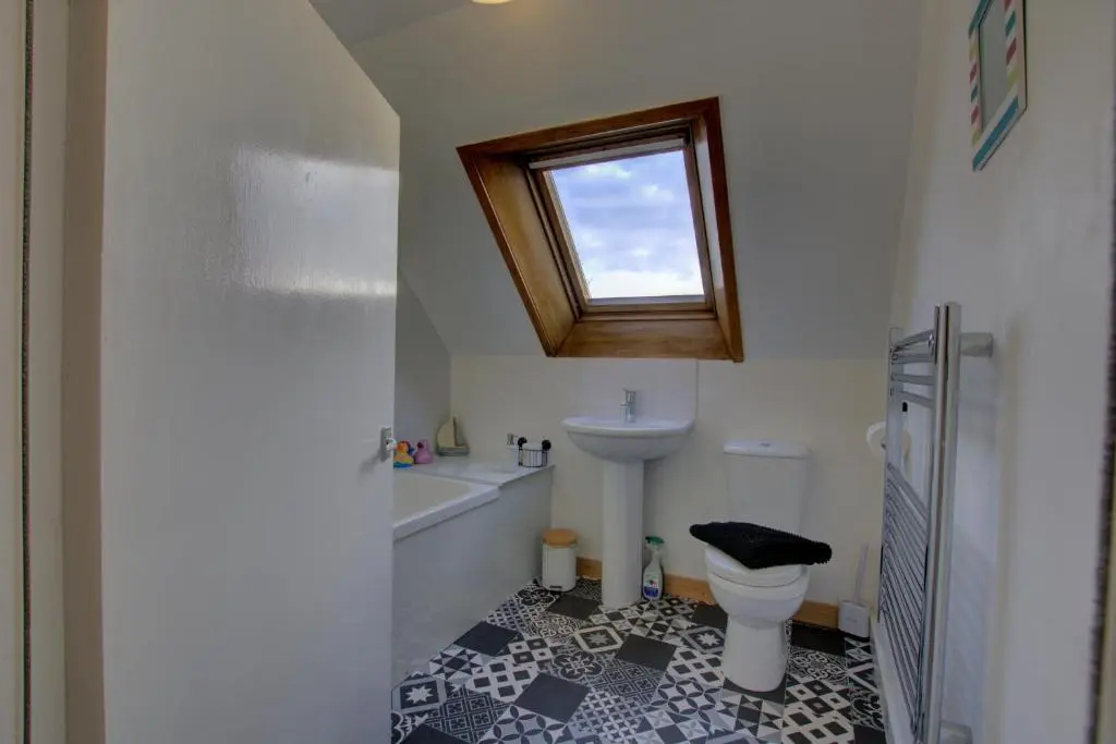 a bathroom with a sink and a toilet and a window at Tigh-na-Mara, Helmsdale in Helmsdale