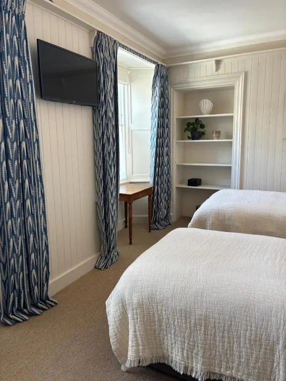 a hotel room with two beds and a flat screen tv at Hootananny in Inverness