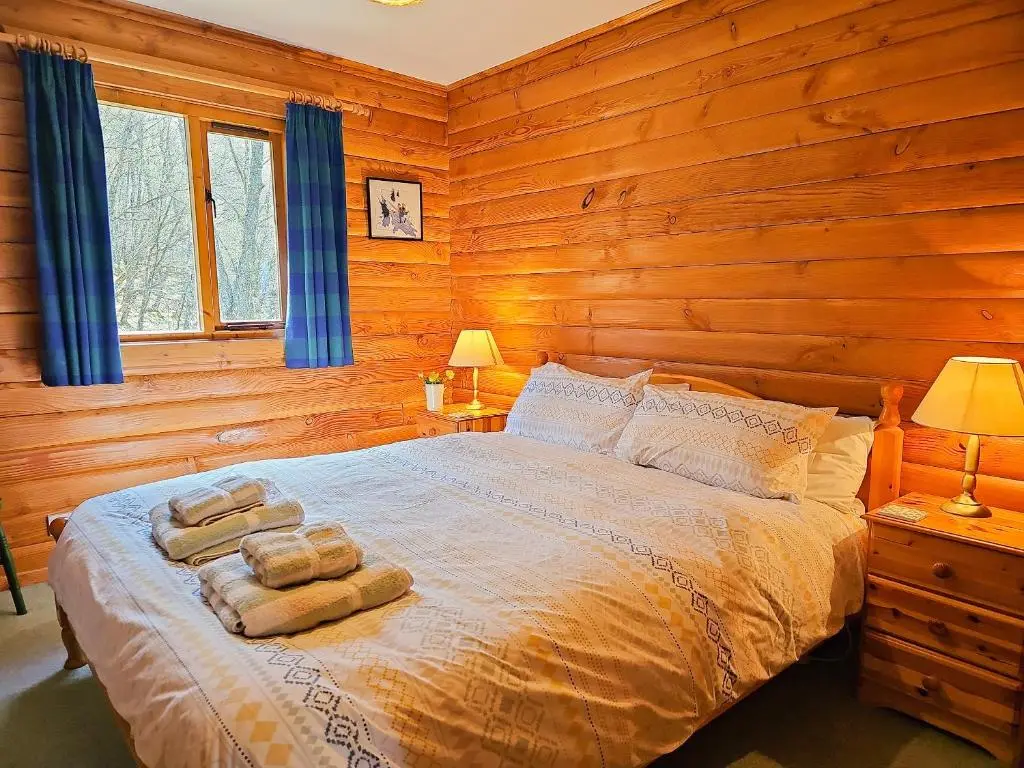 a bedroom with a bed with towels on it at Balbeag Cottage in Insh