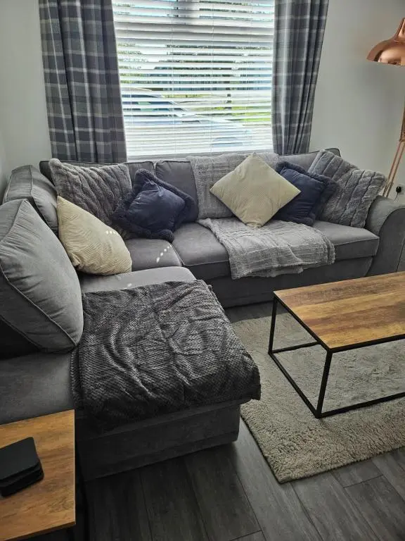 a living room with a couch and a coffee table at 5 Fulmar Road**Next to West Beach and Golf Course in Lossiemouth