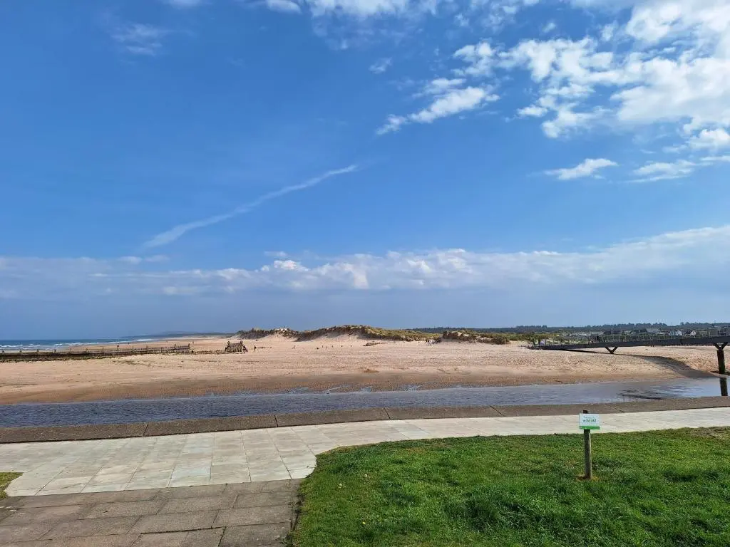 a view of a beach with a bridge and a body of water at 5 Fulmar Road**Next to West Beach and Golf Course in Lossiemouth