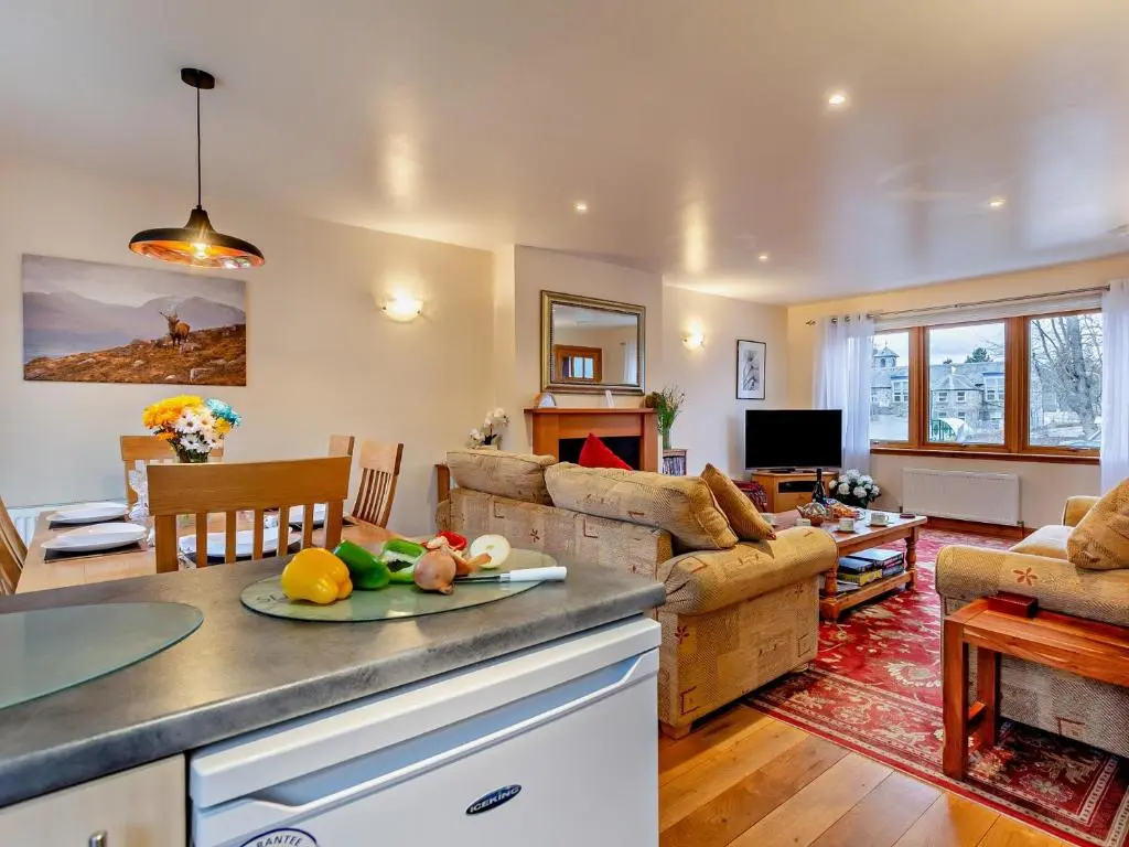a kitchen and living room with a couch and a table at 3 Bed in Grantown-on-Spey 94514 in Grantown on Spey