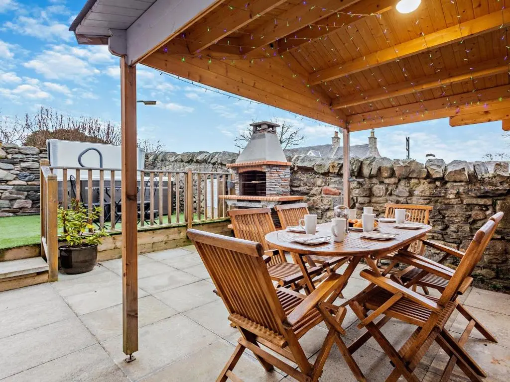 a patio with a table and chairs and a grill at 3 Bed in Grantown-on-Spey 94514 in Grantown on Spey