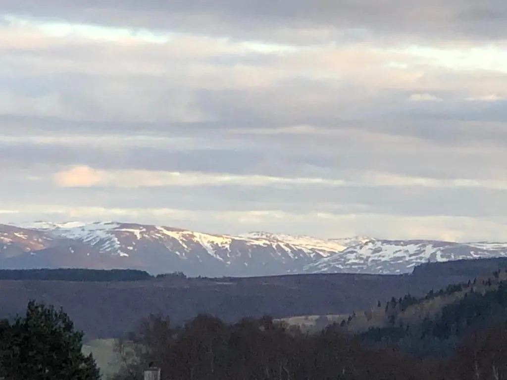 a view of snow covered mountains in the distance at Retreat Hot Tub Highland Cabin in Inverness