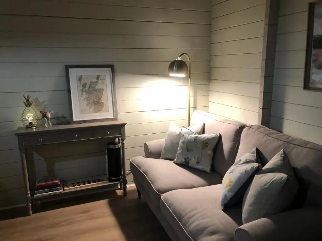 a living room with a couch and a lamp at Retreat Hot Tub Highland Cabin in Inverness