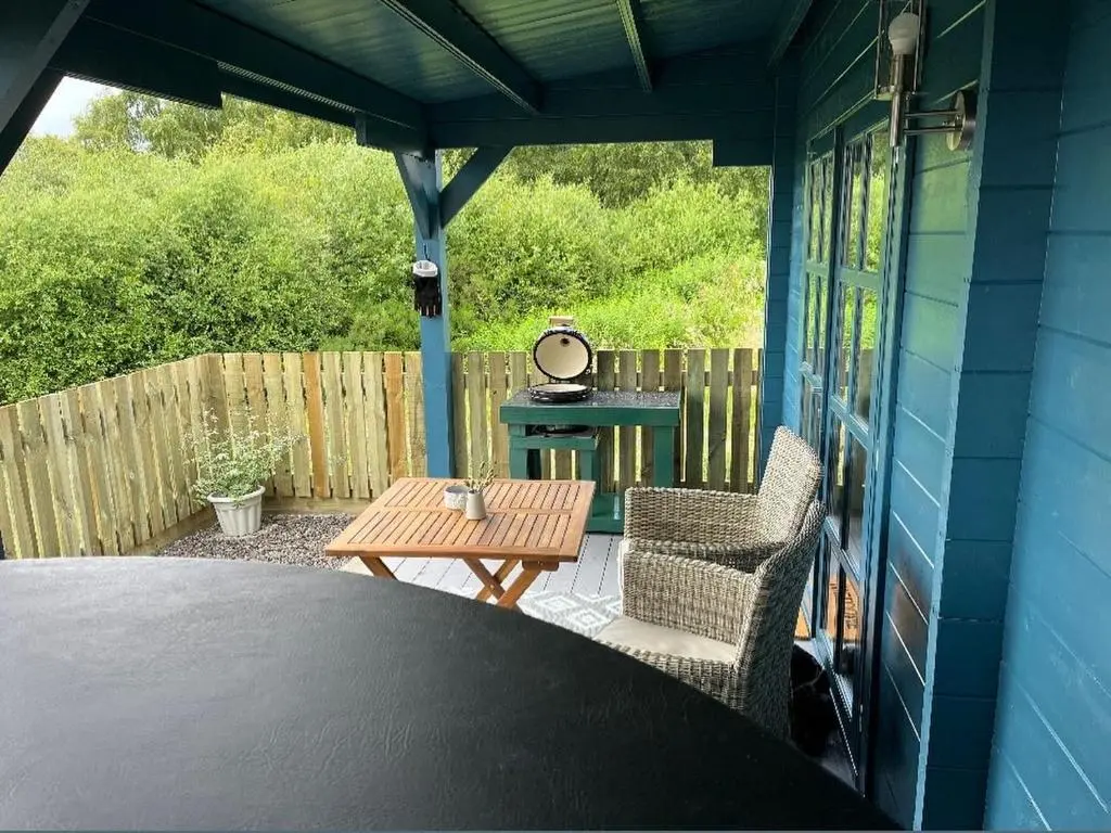 a screened in porch with a table and chairs at Retreat Hot Tub Highland Cabin in Inverness