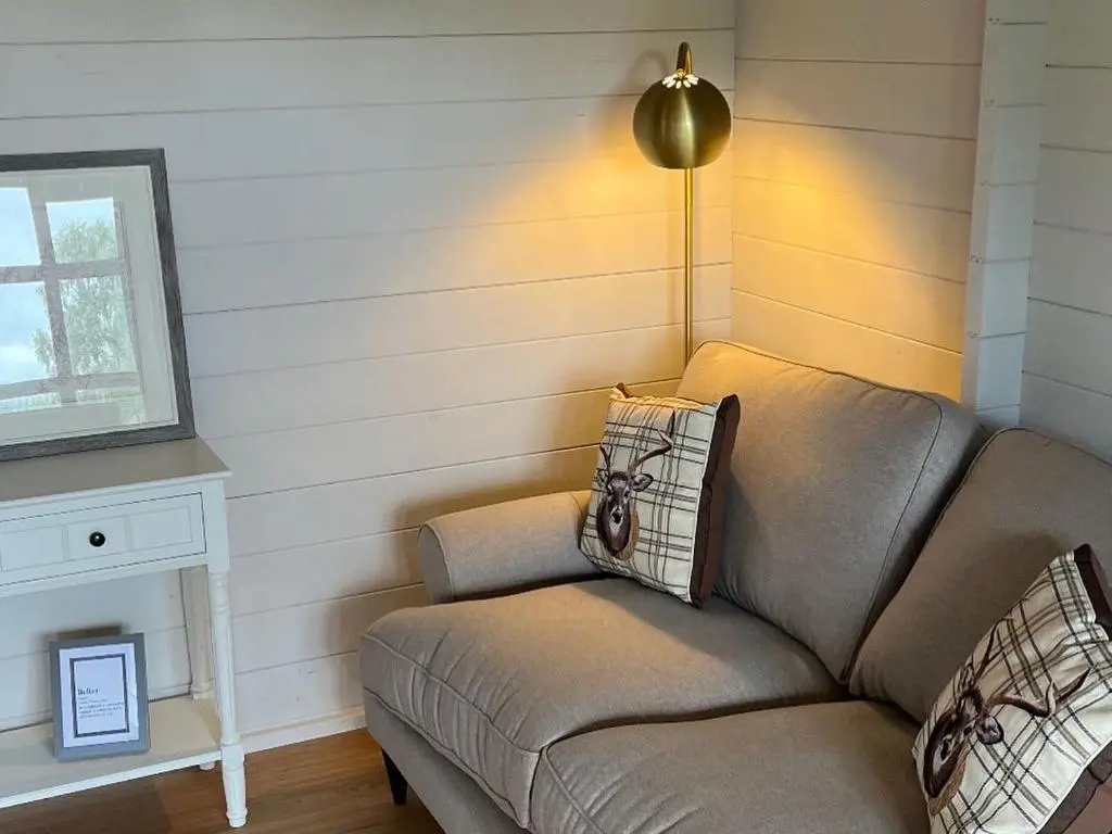 a living room with a couch and a lamp at Retreat Hot Tub Highland Cabin in Inverness
