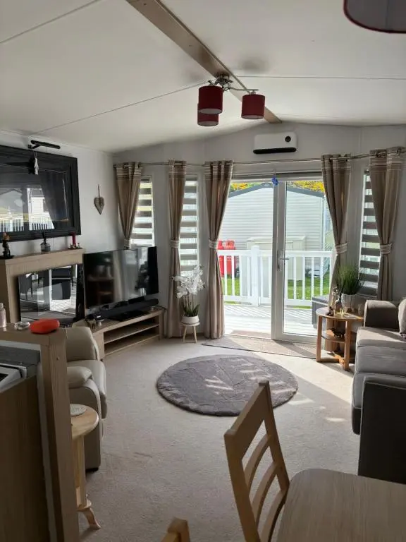 a living room with a couch and a tv and a table at Silversands Holiday Park in Lossiemouth
