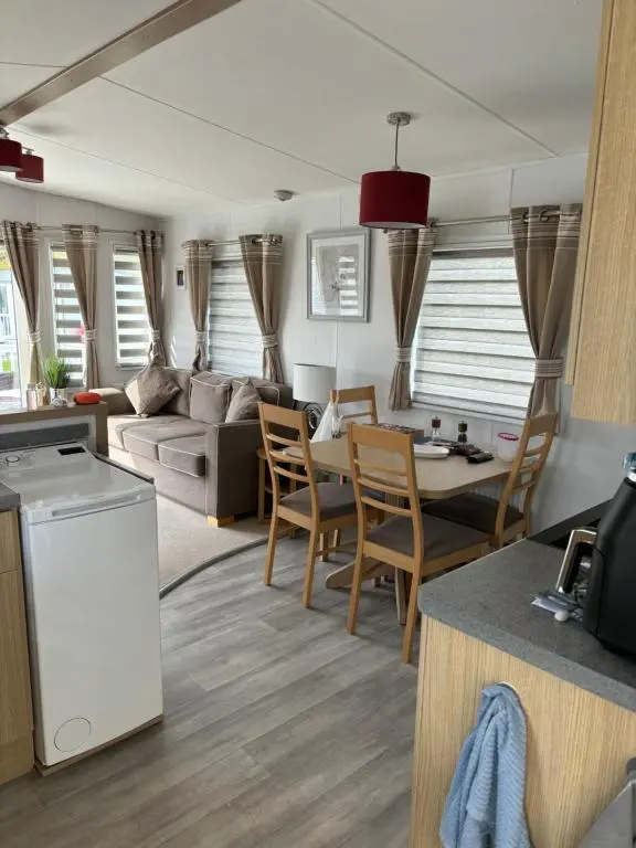 a kitchen and living room with a couch and a table at Silversands Holiday Park in Lossiemouth