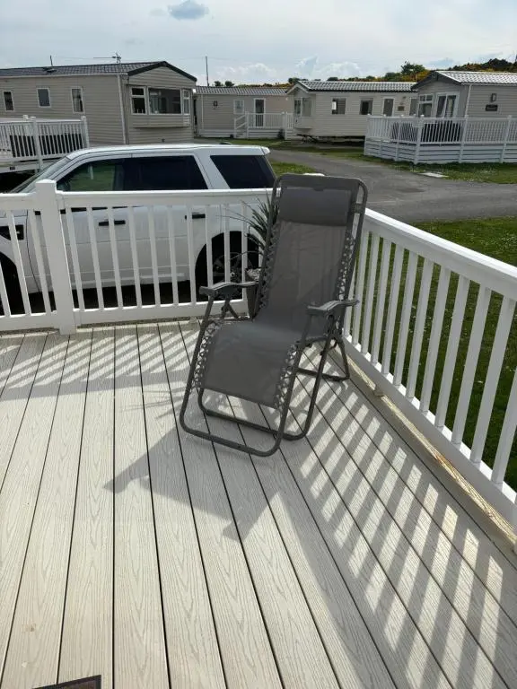 a rocking chair on the deck of a house at Silversands Holiday Park in Lossiemouth
