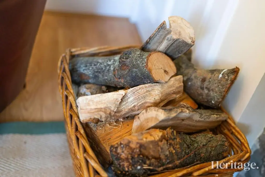 a basket filled with logs and wood sticks at Station Cottage Dinnet, Aboyne in Aboyne