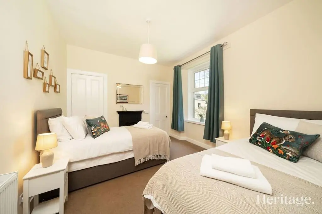a bedroom with two beds and a window at Station Cottage Dinnet, Aboyne in Aboyne
