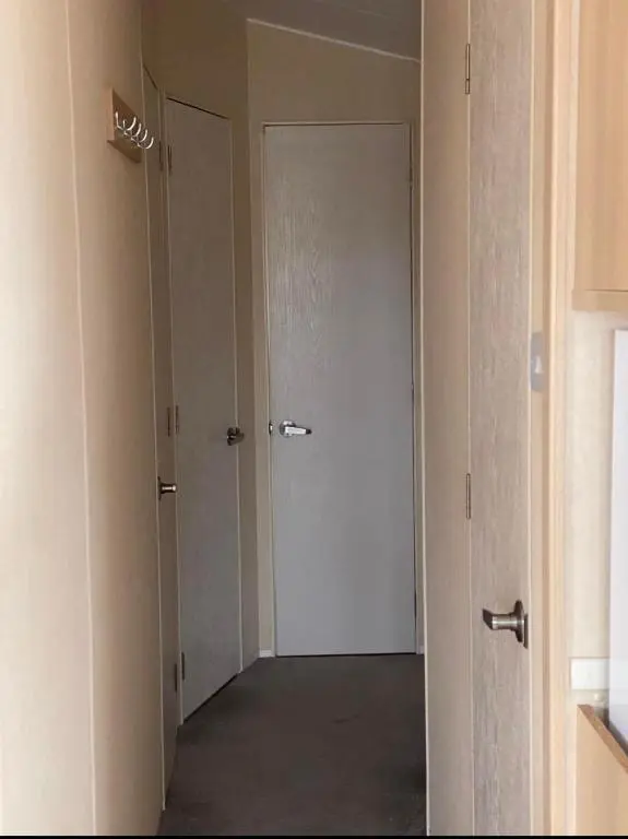 an empty hallway with a white door in a room at Cozy\u2019s caravan hire in Lossiemouth